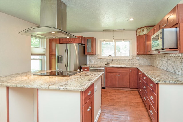 25418 Sugar Valley Ln, Spring, TX 77373 - kitchen featuring stainless steel appliances, island range hood, light wood finished floors, decorative backsplash, and a textured ceiling