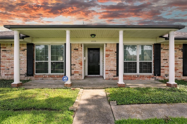8503 Leader St, Houston, TX 77036 - exterior entry at dusk featuring covered porch and brick siding