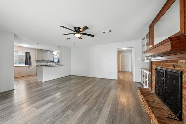 8503 Leader St, Houston, TX 77036 - unfurnished living room with a fireplace, ceiling fan, and wood finished floors