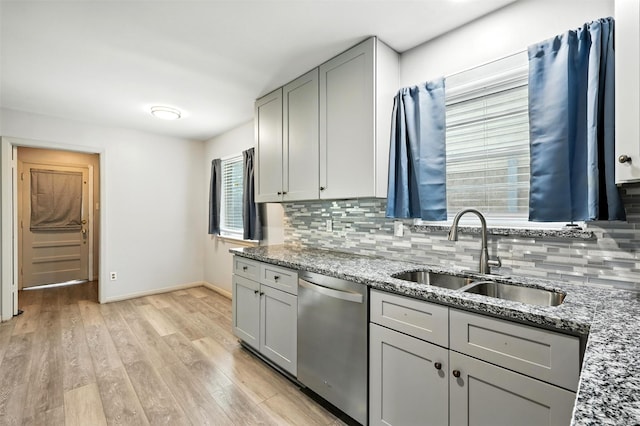 8503 Leader St, Houston, TX 77036 - kitchen featuring stainless steel dishwasher, backsplash, light stone counters, and light wood-type flooring