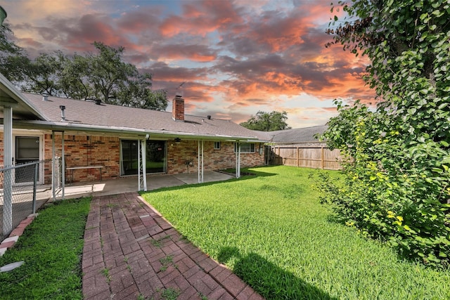 8503 Leader St, Houston, TX 77036 - back of house at dusk with a chimney, a patio, a fenced backyard, and brick siding