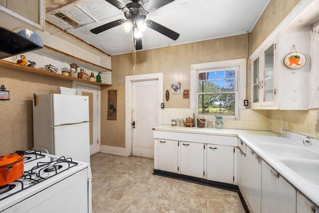 600 Brazos St, Glidden, TX 78943 - kitchen with white appliances, ceiling fan, light countertops, white cabinets, and glass insert cabinets