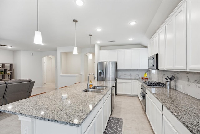 1502 Trails Of Katy Ln, Katy, TX 77494 - kitchen featuring arched walkways, appliances with stainless steel finishes, decorative backsplash, white cabinetry, and open floor plan