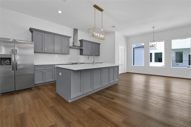 209 Edgewood St Unit C, Houston, TX 77011 - kitchen featuring stainless steel fridge with ice dispenser, wall chimney exhaust hood, gray cabinets, dark wood-style flooring, and a chandelier