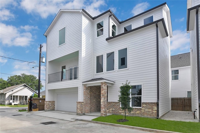 209 Edgewood St Unit C, Houston, TX 77011 - view of front of house with brick siding, a garage, a balcony, and driveway