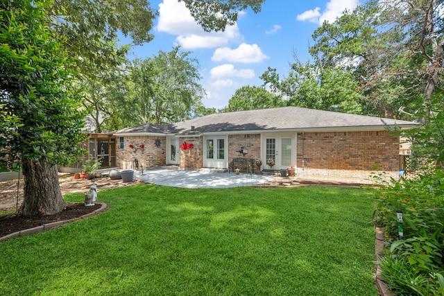 150 Greenbriar Dr, Montgomery, TX 77356 - rear view of house with french doors, brick siding, a lawn, a patio area, and a sunroom