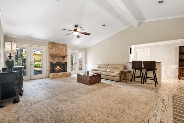 150 Greenbriar Dr, Montgomery, TX 77356 - living room featuring a ceiling fan, wainscoting, a stone fireplace, a decorative wall, and ornamental molding
