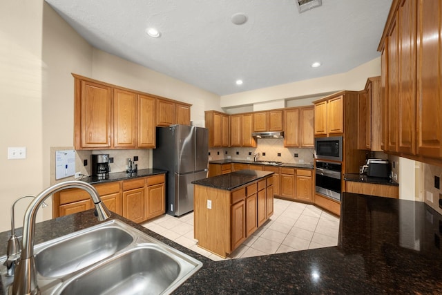 18718 Glenn Haven Estates Dr, Spring, TX 77379 - kitchen with appliances with stainless steel finishes, decorative backsplash, a center island, light tile patterned flooring, and brown cabinets