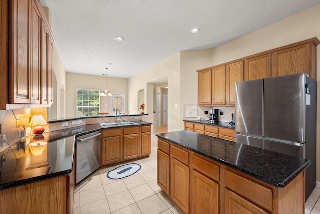 18718 Glenn Haven Estates Dr, Spring, TX 77379 - kitchen featuring appliances with stainless steel finishes, tasteful backsplash, brown cabinetry, recessed lighting, and light tile patterned floors
