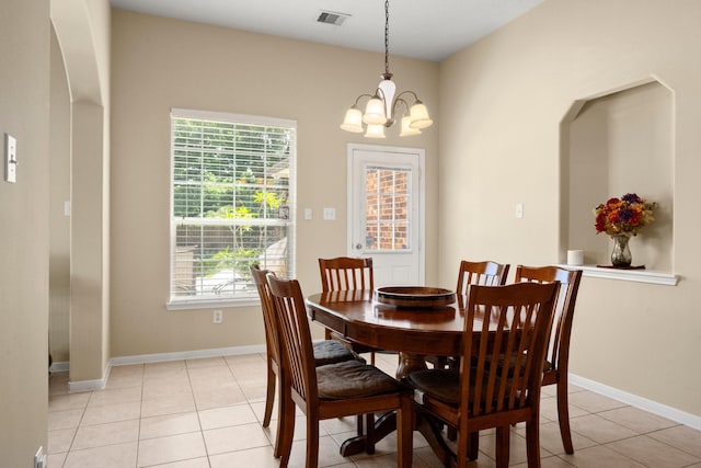 18718 Glenn Haven Estates Dr, Spring, TX 77379 - dining room with healthy amount of natural light, a chandelier, light tile patterned floors, and arched walkways