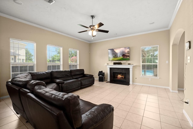 18718 Glenn Haven Estates Dr, Spring, TX 77379 - living area featuring crown molding, ceiling fan, light tile patterned flooring, a tile fireplace, and arched walkways