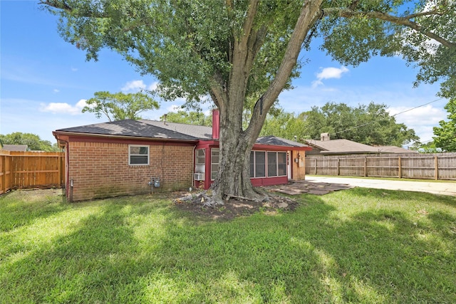 10447 Winding Trail Rd, La Porte, TX 77571 - rear view of house with a fenced backyard, brick siding, a patio area, and a sunroom