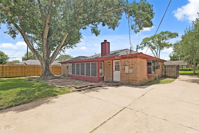 10447 Winding Trail Rd, La Porte, TX 77571 - back of property with brick siding, a chimney, a patio area, a sunroom, and a shingled roof