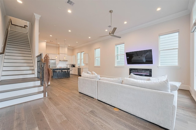 5308 S Capitol St, Houston, TX 77023 - living room with crown molding, stairway, ceiling fan, light wood finished floors, and recessed lighting