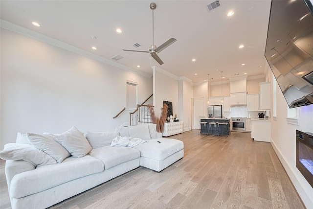 5308 S Capitol St, Houston, TX 77023 - living area featuring ornamental molding, light wood finished floors, recessed lighting, stairs, and ceiling fan