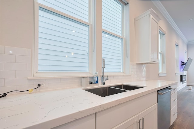 5308 S Capitol St, Houston, TX 77023 - kitchen featuring crown molding, white cabinets, light stone countertops, decorative backsplash, and dark wood-type flooring