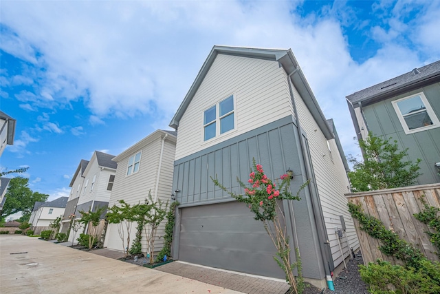 5308 S Capitol St, Houston, TX 77023 - view of property exterior featuring board and batten siding, a garage, driveway, and a residential view