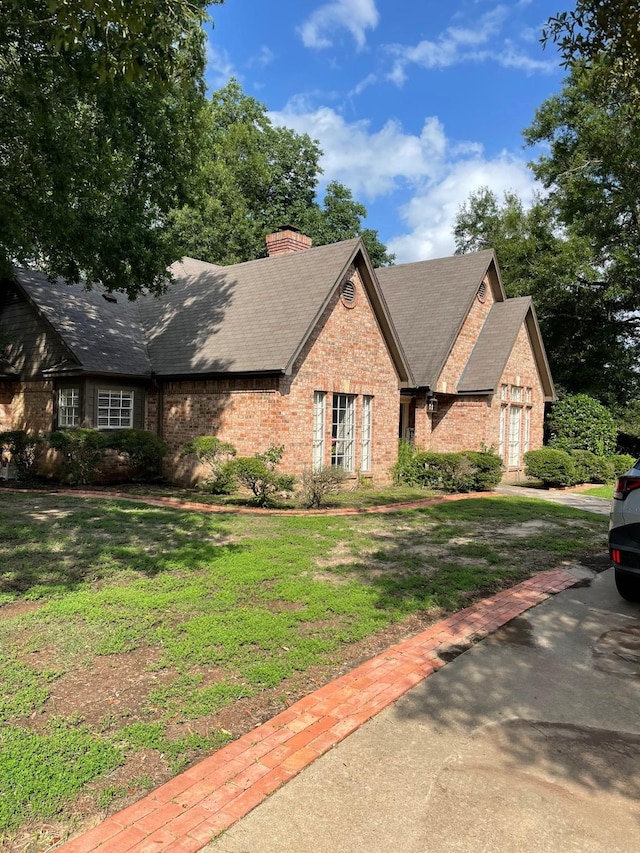 1200 Mary Lee Ln, Crockett, TX 75835 - view of front of home with brick siding, a chimney, a front lawn, a shingled roof, and a garage