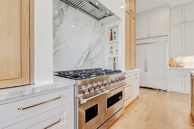 6911 Hartland Ave, Houston, TX 77055 - kitchen with high quality appliances, custom range hood, light stone countertops, light wood finished floors, and backsplash