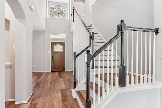 2551 Goldeneye Ln, League City, TX 77573 - foyer entrance featuring wood finished floors, a chandelier, stairway, and arched walkways
