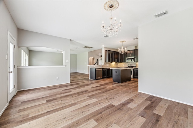 2551 Goldeneye Ln, League City, TX 77573 - kitchen with stainless steel appliances, a chandelier, open floor plan, light countertops, and decorative backsplash