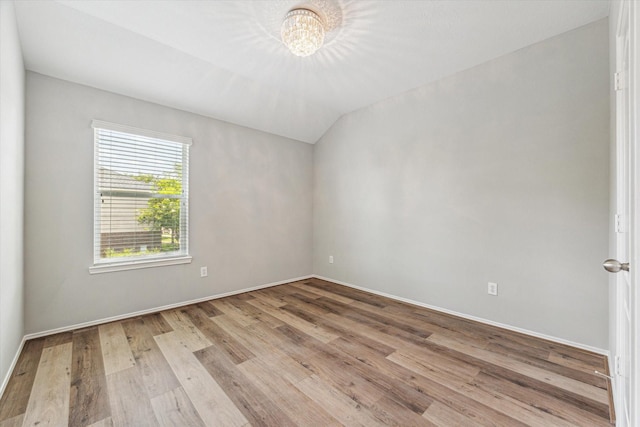 2551 Goldeneye Ln, League City, TX 77573 - empty room featuring a chandelier, wood finished floors, and vaulted ceiling