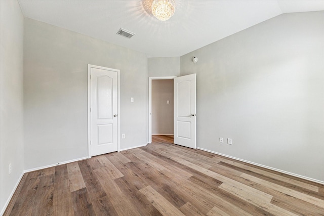 2551 Goldeneye Ln, League City, TX 77573 - unfurnished bedroom featuring wood finished floors and a chandelier