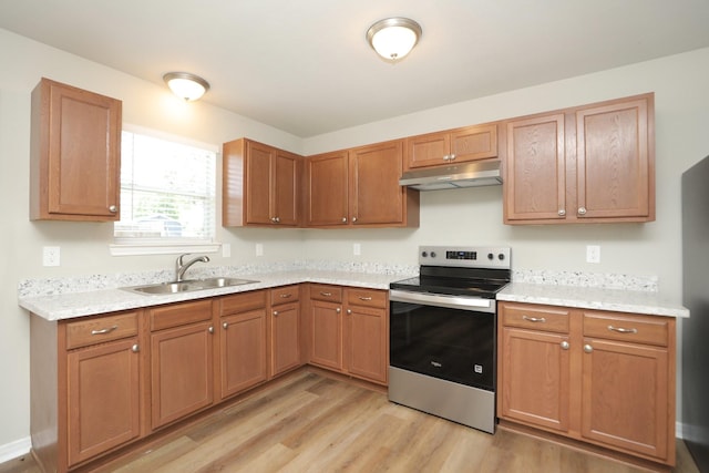1440 Shepherd St, Hempstead, TX 77445 - kitchen with stainless steel range with electric stovetop, under cabinet range hood, light countertops, light wood finished floors, and brown cabinetry