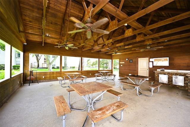 9809 Richmond Ave Unit G1, Houston, TX 77042 - carpeted living area featuring healthy amount of natural light, a ceiling fan, wood walls, high vaulted ceiling, and a wooden ceiling with exposed beams