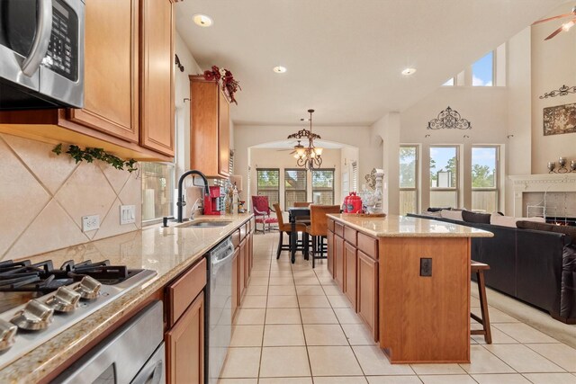 14306 Prosper Ridge Dr, Cypress, TX 77429 - kitchen with stainless steel appliances, arched walkways, decorative backsplash, light tile patterned floors, and open floor plan