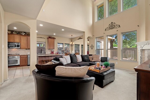 14306 Prosper Ridge Dr, Cypress, TX 77429 - living area featuring light colored carpet, a towering ceiling, arched walkways, recessed lighting, and a chandelier