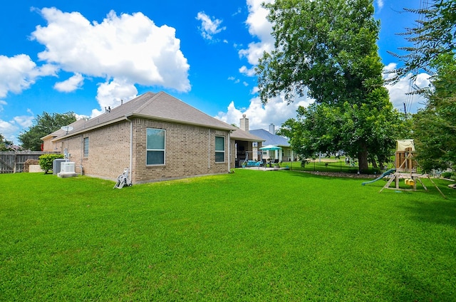 33215 Worthing Ln, Fulshear, TX 77441 - rear view of property featuring brick siding, a playground, and a fenced backyard