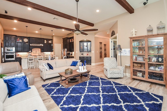 33215 Worthing Ln, Fulshear, TX 77441 - living room featuring beamed ceiling, arched walkways, a ceiling fan, light wood-style floors, and recessed lighting