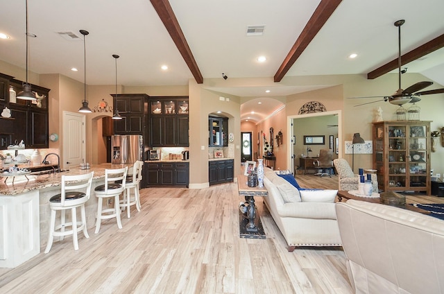 33215 Worthing Ln, Fulshear, TX 77441 - living room featuring a ceiling fan, arched walkways, beam ceiling, light wood-style floors, and recessed lighting