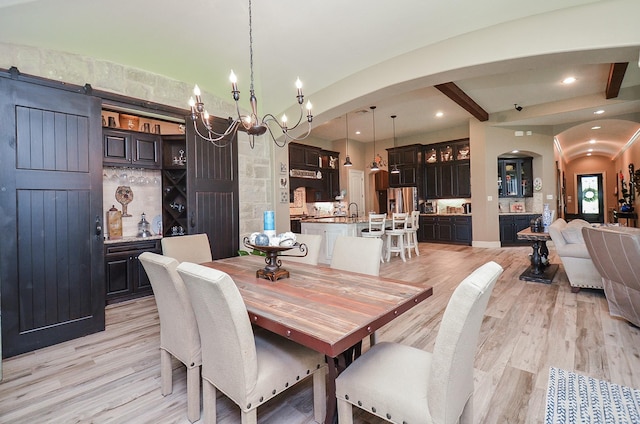 33215 Worthing Ln, Fulshear, TX 77441 - dining room featuring arched walkways, light wood-style flooring, a chandelier, beamed ceiling, and recessed lighting