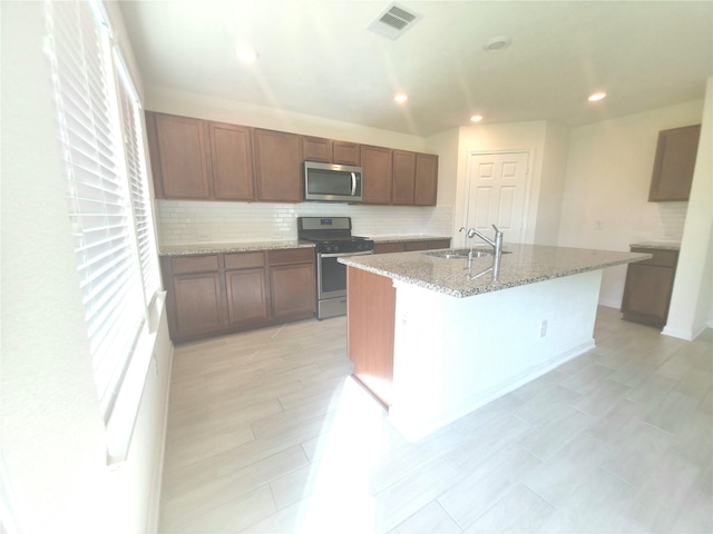 4122 Mossy Bank Ln, Houston, TX 77068 - kitchen featuring stainless steel appliances, healthy amount of natural light, tasteful backsplash, an island with sink, and recessed lighting