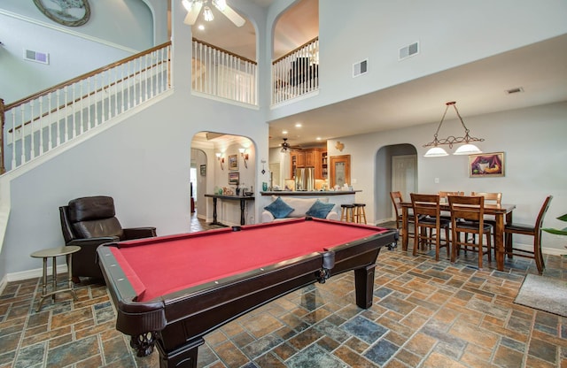 16506 Dawson Mill Ct, Houston, TX 77095 - playroom featuring ceiling fan, stone tile flooring, arched walkways, pool table, and a high ceiling