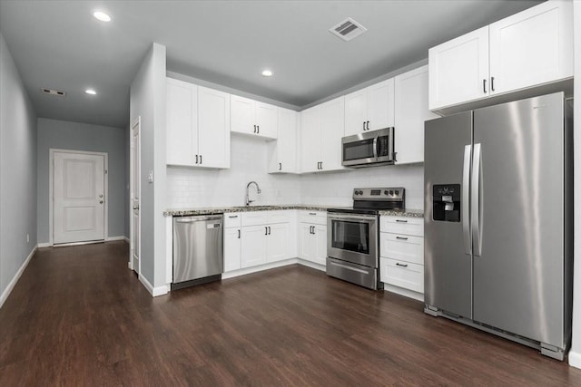 4935 Ambient Dr, Spring, TX 77379 - kitchen featuring stainless steel appliances, dark wood-style flooring, white cabinets, backsplash, and recessed lighting