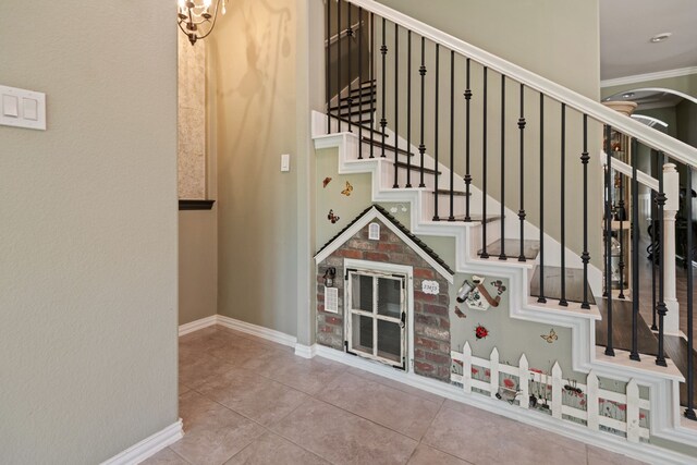 23613 Alder Branch Ln, New Caney, TX 77357 - staircase with crown molding, tile patterned flooring, and arched walkways