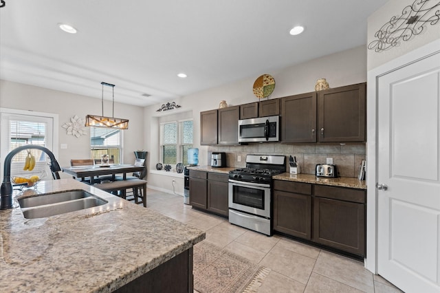 6923 Glenmoor Dr, Rosharon, TX 77583 - kitchen with stainless steel appliances, decorative backsplash, healthy amount of natural light, dark brown cabinets, and recessed lighting