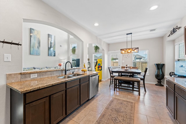 6923 Glenmoor Dr, Rosharon, TX 77583 - kitchen featuring stainless steel dishwasher, dark brown cabinetry, light stone countertops, decorative light fixtures, and recessed lighting