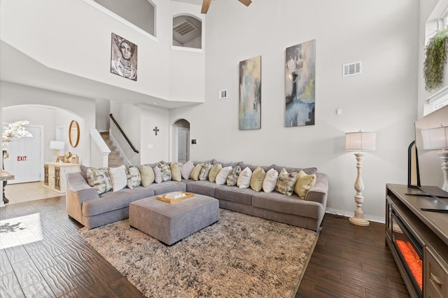6923 Glenmoor Dr, Rosharon, TX 77583 - living area with arched walkways, a high ceiling, stairway, dark wood-style floors, and a ceiling fan
