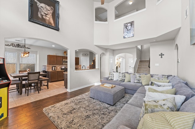 6923 Glenmoor Dr, Rosharon, TX 77583 - living area with wood-type flooring, arched walkways, a towering ceiling, and stairway