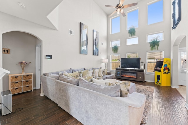 6923 Glenmoor Dr, Rosharon, TX 77583 - living area featuring arched walkways, ceiling fan, a towering ceiling, and dark wood finished floors