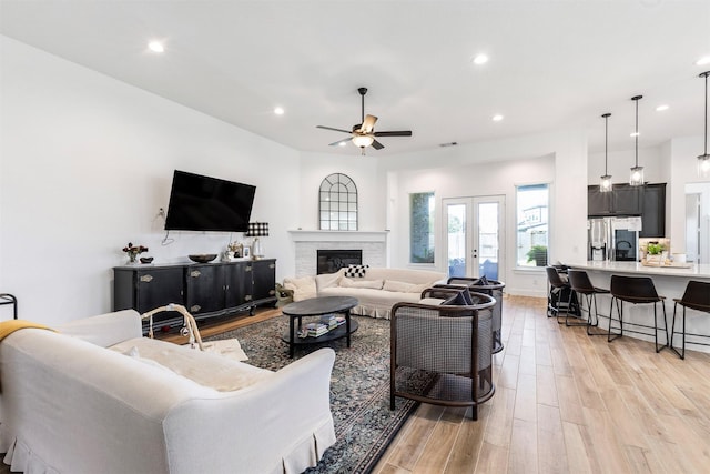 1703 Rosings Way, Katy, TX 77493 - living area featuring light wood-type flooring, a ceiling fan, recessed lighting, a glass covered fireplace, and french doors