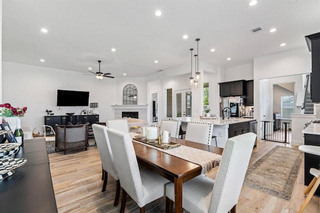 1703 Rosings Way, Katy, TX 77493 - dining room featuring a ceiling fan, recessed lighting, light wood finished floors, and a fireplace