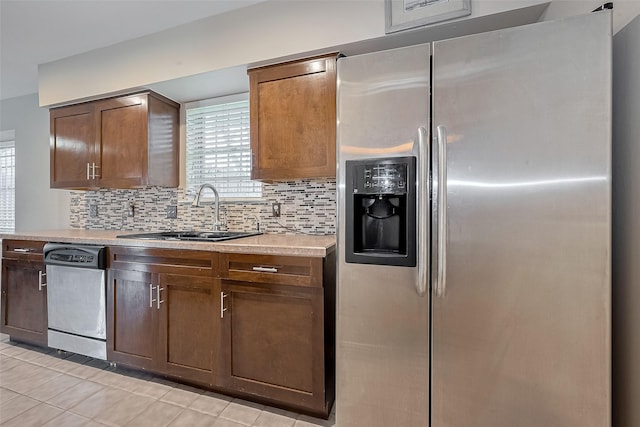 7230 Redding Rd, Houston, TX 77036 - kitchen with stainless steel appliances, decorative backsplash, light countertops, and light tile patterned flooring