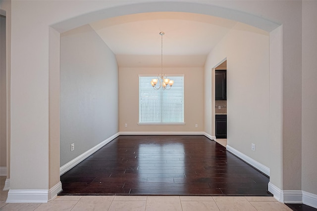 310 Blossom Terrace Ln, Rosenberg, TX 77469 - unfurnished dining area featuring a chandelier, hardwood / wood-style floors, arched walkways, and lofted ceiling