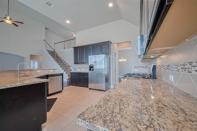 310 Blossom Terrace Ln, Rosenberg, TX 77469 - kitchen with appliances with stainless steel finishes, high vaulted ceiling, ceiling fan, backsplash, and light stone counters