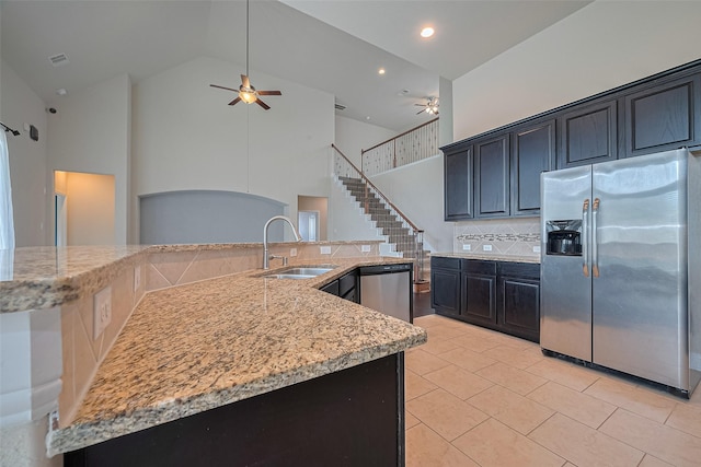 310 Blossom Terrace Ln, Rosenberg, TX 77469 - kitchen featuring appliances with stainless steel finishes, a ceiling fan, tasteful backsplash, light stone counters, and high vaulted ceiling